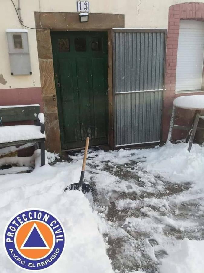 Los voluntarios de Protección Civil despejan la nieve caída en los últimos días en Ferreras del Puerto.