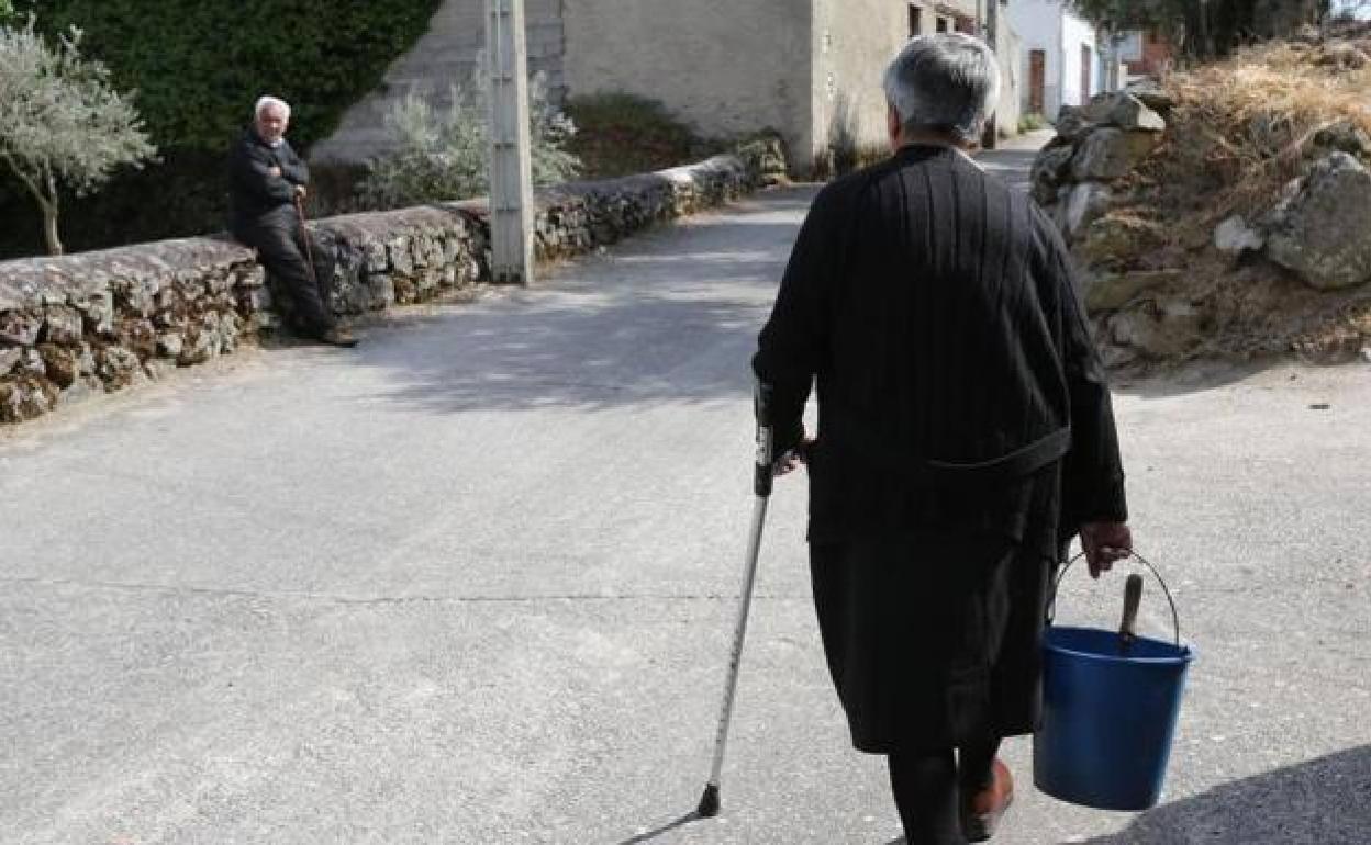 Imagen de una anciana en un pueblo.