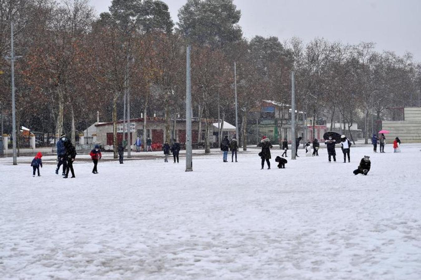 Varias personas caminan este jueves entre la nieve por el Paseo de la Feria de Albacete.