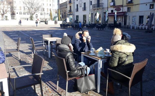 Algunos leoneses se aventuran a disfrutr de las terrazas en León con temperaturas bajo cero el primer día de las nuevas restricciones.