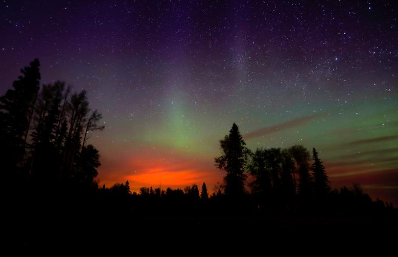 Los incendios forestales brillan debajo de la aurora boreal, cerca de Fort McMurray, Alberta, Canadá, mayo de 2016.