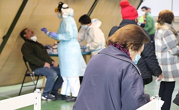 Galería. Una mujer espera a la cola mientras un hombre se hace el test.