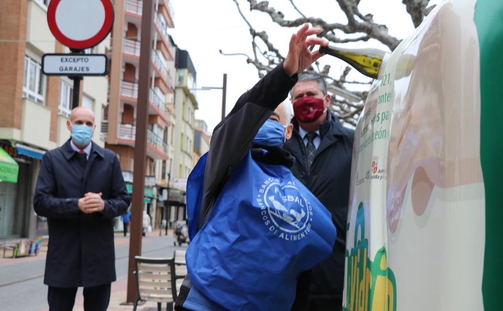 Un voluntario del Banco de Alimentos deposita una botella en el contenedor.