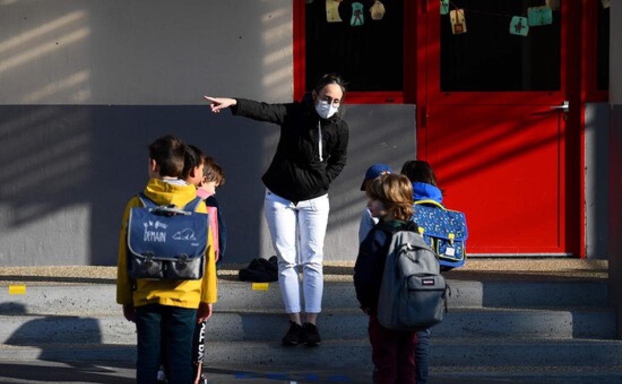 Una profesora organiza la entrada al colegio a un grupo de alumnos franceses según las normas sanitarias