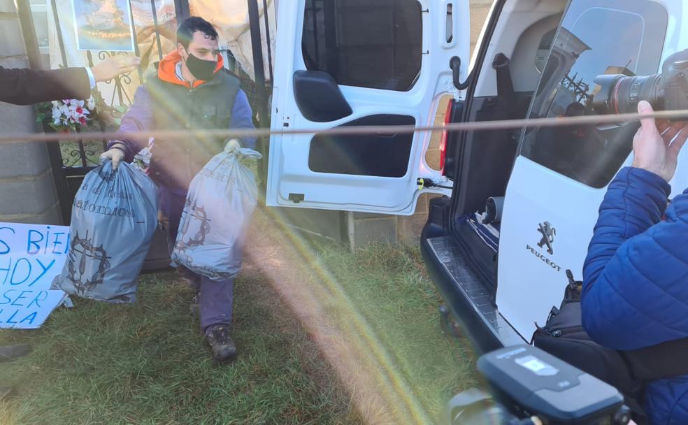 Un trabajador de la funeraria retira en unas bolsas los restos mortales de Araceli y Martín del cementerio de Abadengo de Torío.