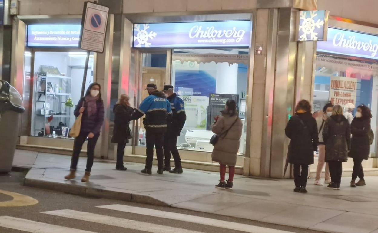 Una patrulla de la Policía Local con la mujer que ha caído al suelo. 