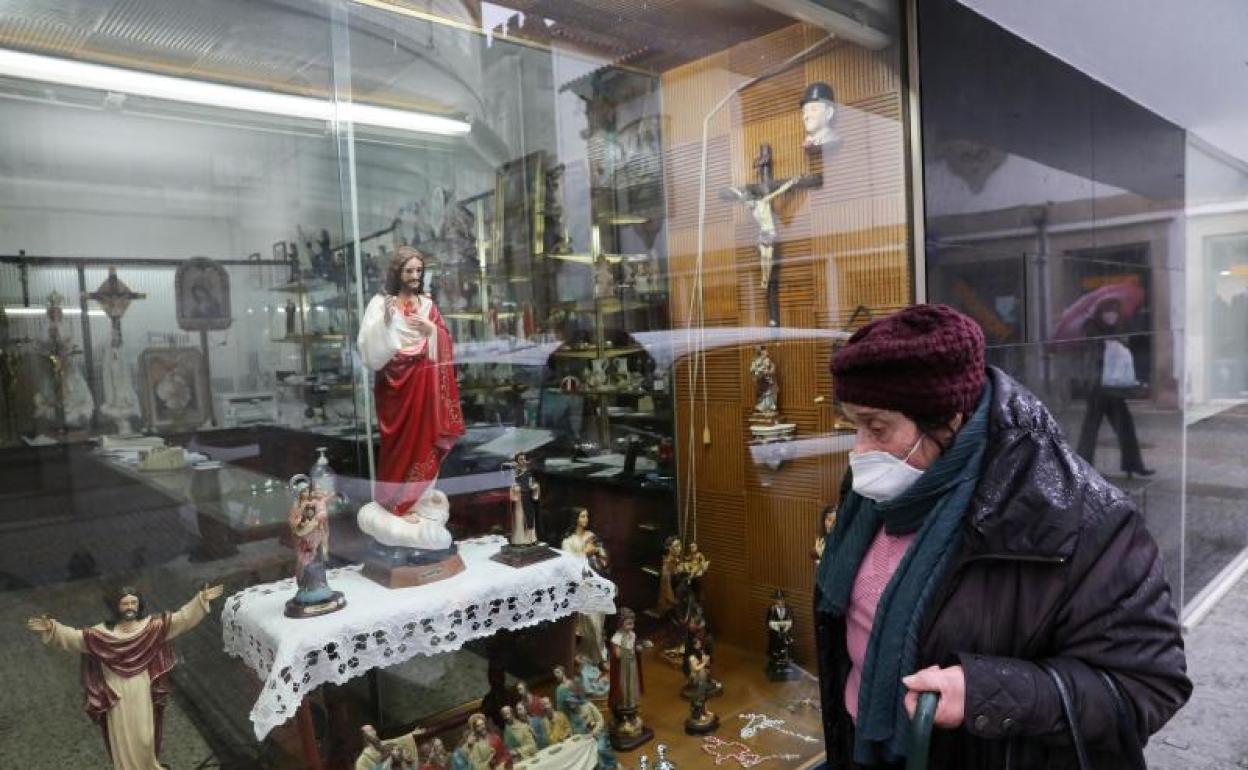 Una mujer camina delante del escaparate de una tienda en la localidad portuguesa de Vila Real.