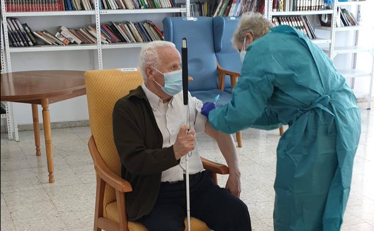 Una enfermera vacuna a un anciano en una residencia.