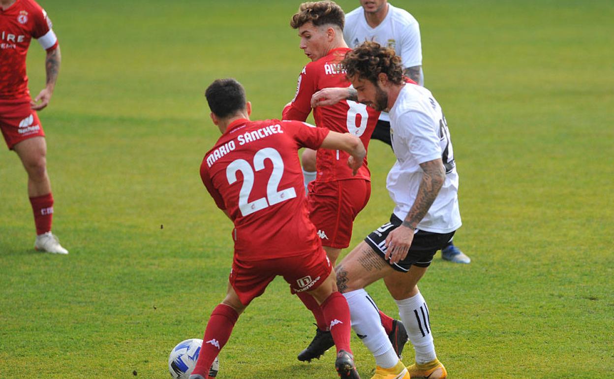 Los jugadores de la Cultural disputan un balón ante el Burgos.