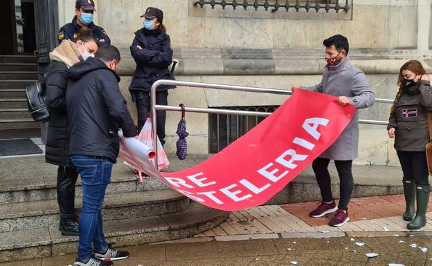 Galería. Un grupo de hosteleros recogen la pancarta tras la concentración.