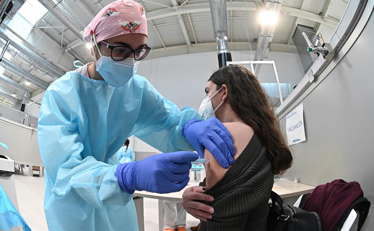 Una sanitaria pone la vacuna contra la covid-19 a una mujer en Madrid. 