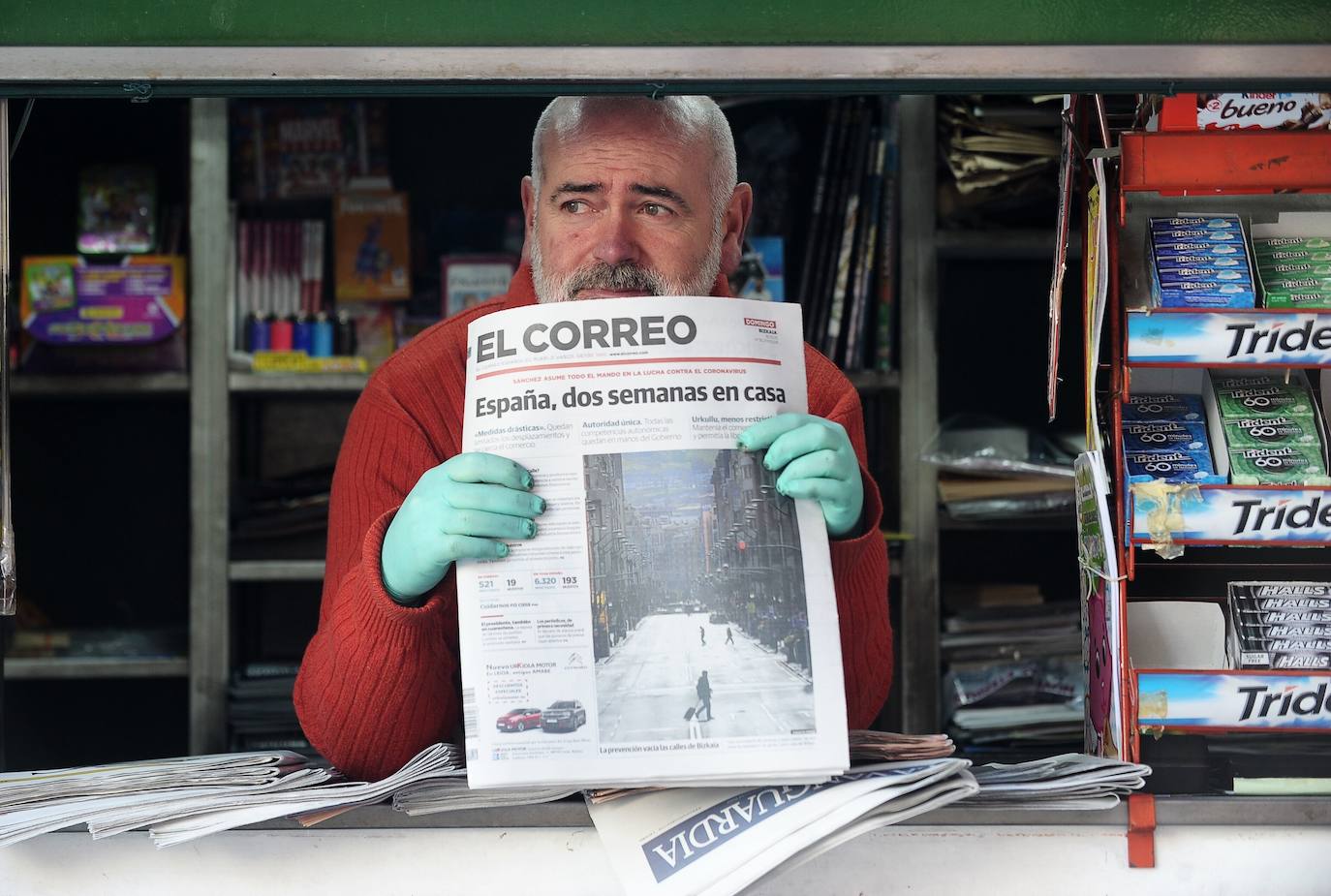 Un quiosquero, con el periódico que anunciaba el estado de alarma durante dos semanas