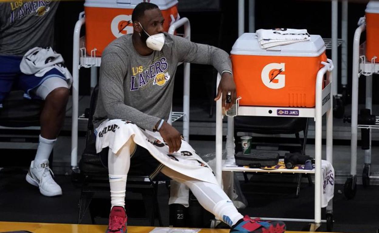 LeBron James, sentado con una mascarilla en un partido entre los Lakers y los Timberwolves. 