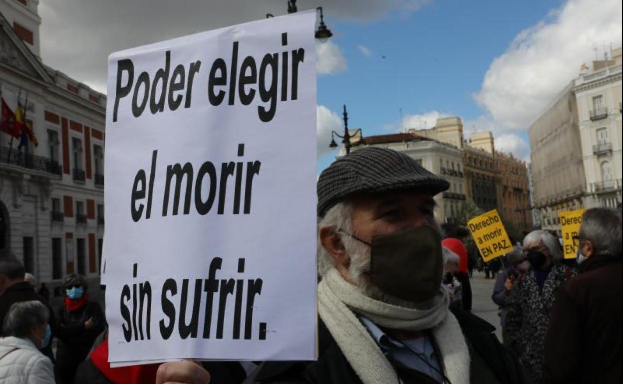 Un hombre con un cartel en el que se lee: `Poder elegir el morir sin sufrir´ durante una concentración de Derecho a Morir Dignamente en la Puerta del Sol, en Madrid 