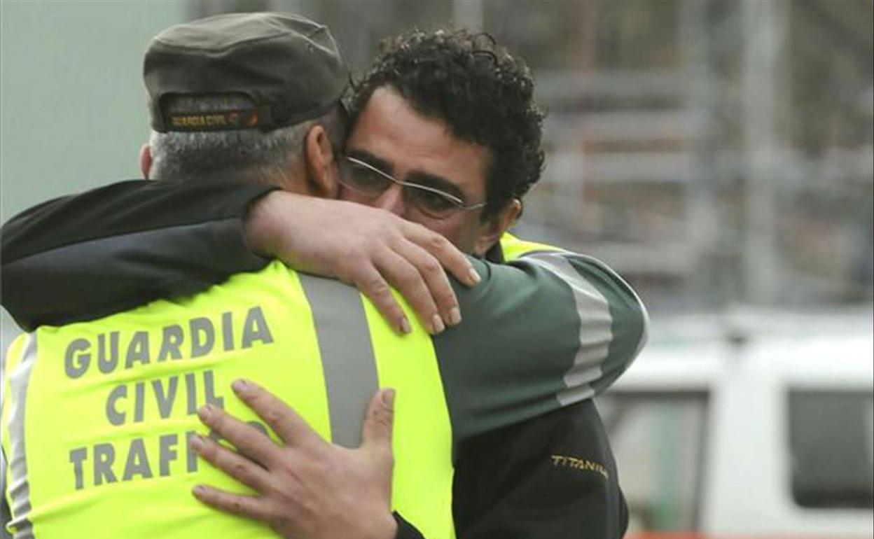 Un Guardia Civil se abraza a un trabajador en la jornada del accidente. 