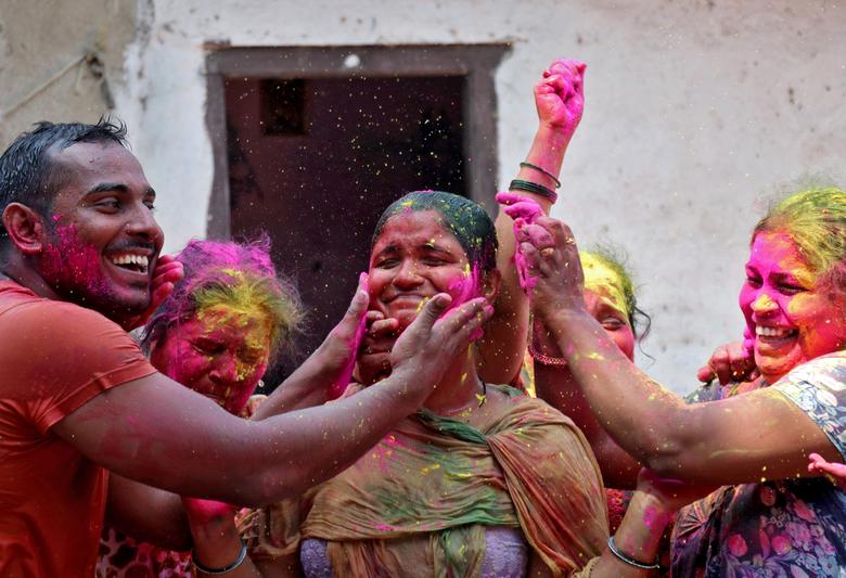 Una mujer reacciona cuando se le aplica polvo de color en la cara durante las celebraciones de Holi en Mumbai, India.