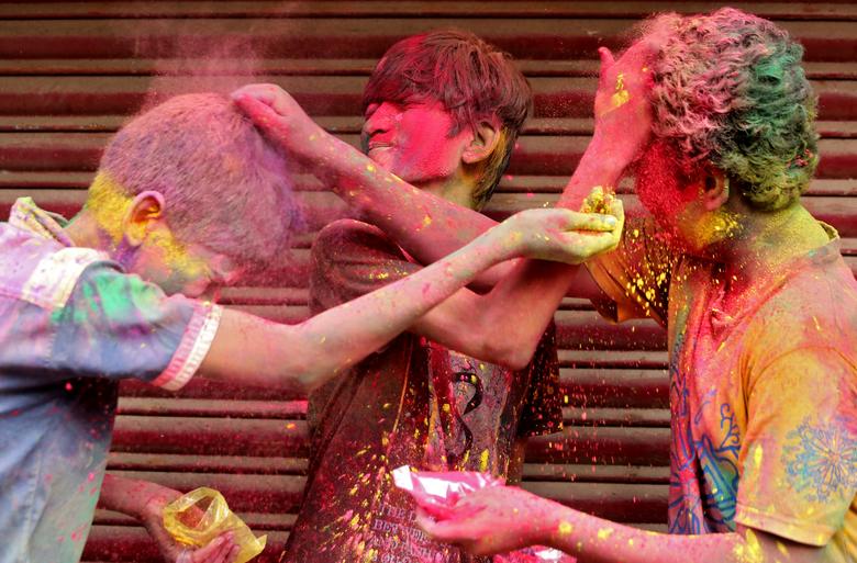 Los niños se aplican polvos durante las celebraciones de Holi en Chennai, India.