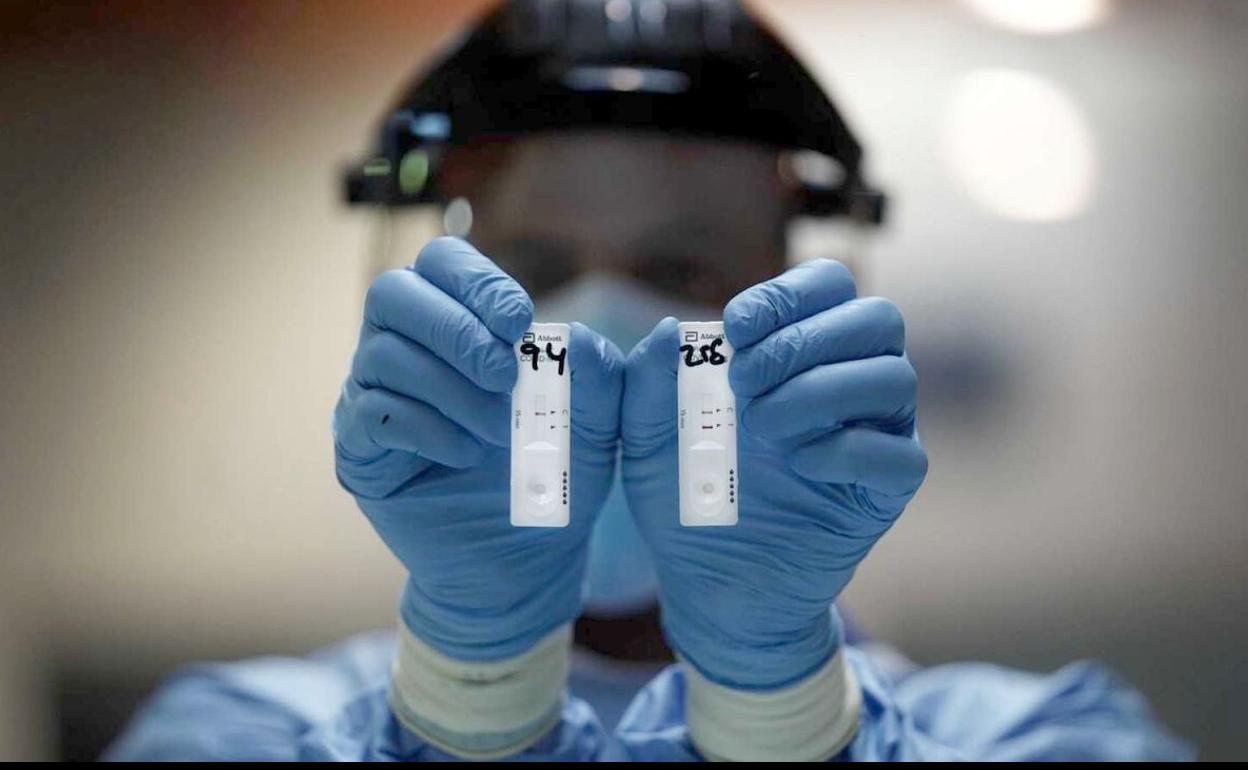 Un sanitario con test para la detección de casos covid.