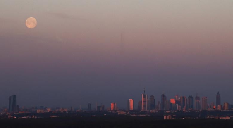 La superluna se pone sobre el horizonte de Frankfurt y la sede del Banco Central Europeo (izqu), Alemania.