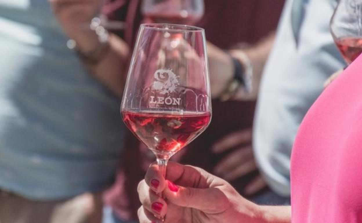 Una mujer sostiene una copa de vino DO León.