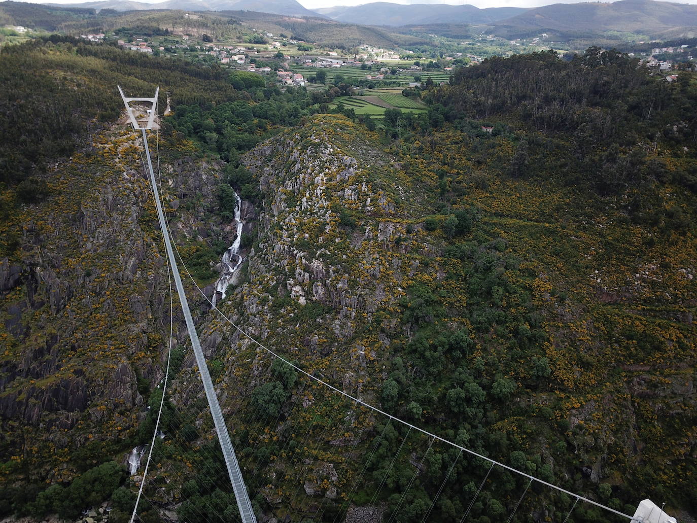 Portugal inauguró este jueves 29 de abril el puente peatonal suspendido más largo del mundo, a 175 metros sobre el río Paiva, en el norte, y que con sus 516 metros supera el récord establecido en 2017 por la pasarela Charles Kuonen de los Alpes suizos. El puente atraviesa un barranco granítico del municipio de Arouca y está formado por 127 planchas de rejilla con barandillas metálicas de 1,20 metros de ancho, sujetas por cables de acero a unos pilares en forma de 'V' situados a cada extremo.