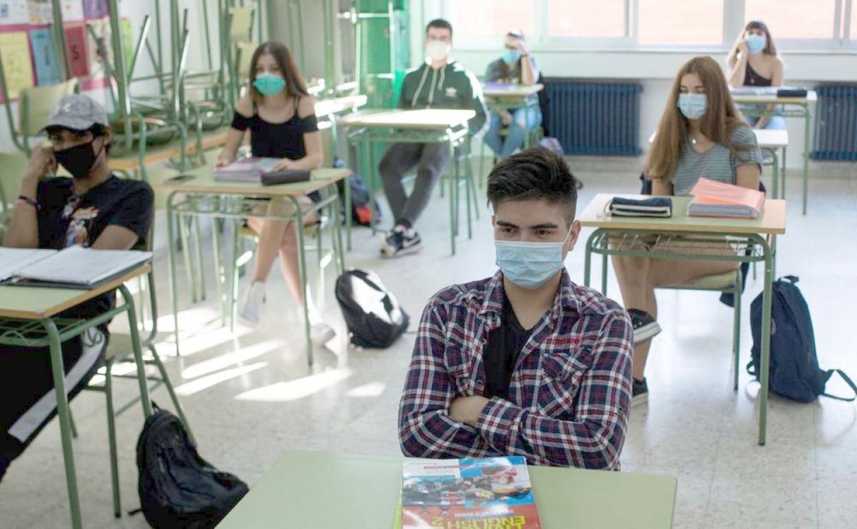 Alumnos en un aula docente manteniendo la distancia de segurtidad. 