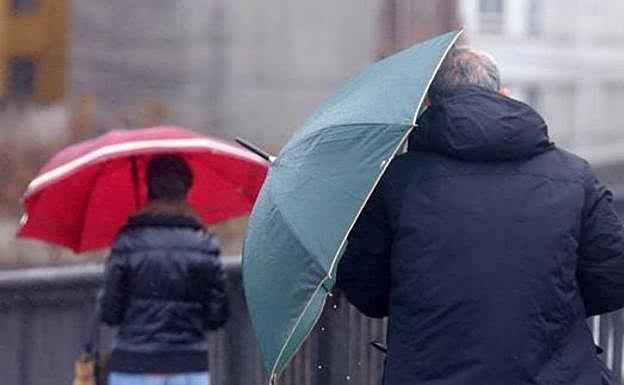 Un hombre se resguarda de la lluvia en León capital.