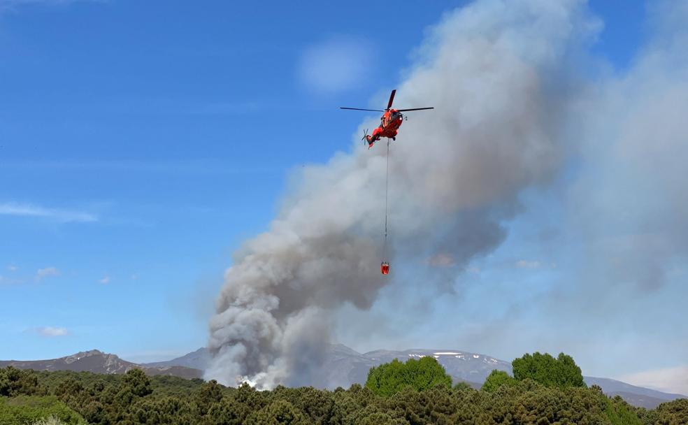 Un helicóptero sobrevuela la zona militar para sofocar el incendio. 