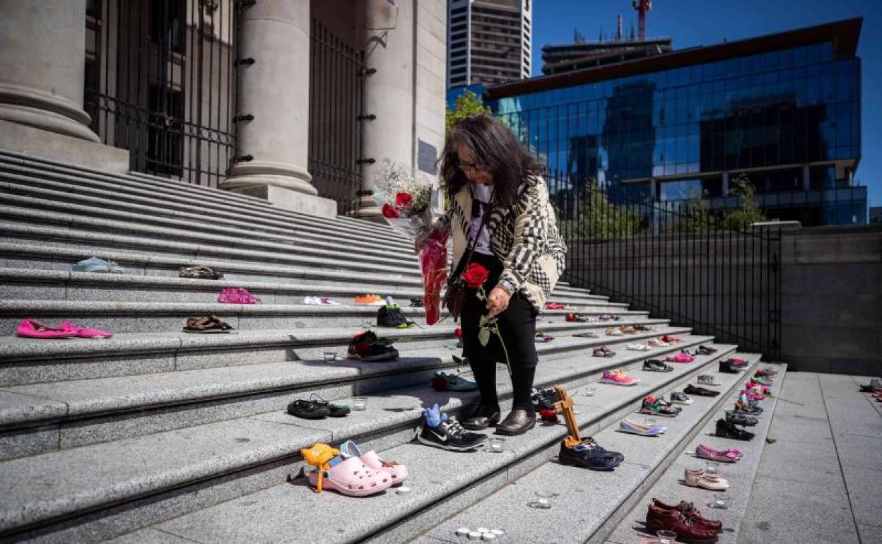 Una mujer deja flores en homenaje a los niños.