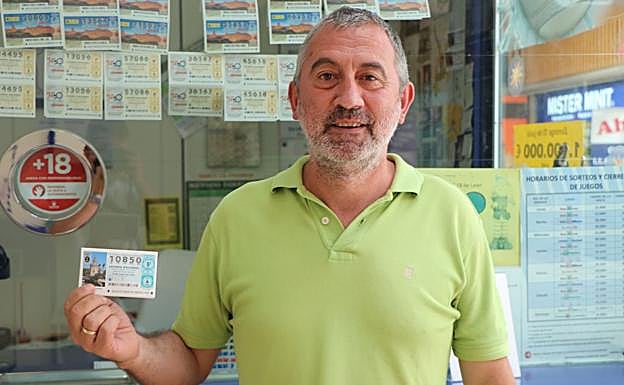 El regente de la administración de Lotería en el Carrefour de León posa con el boleto premiado..