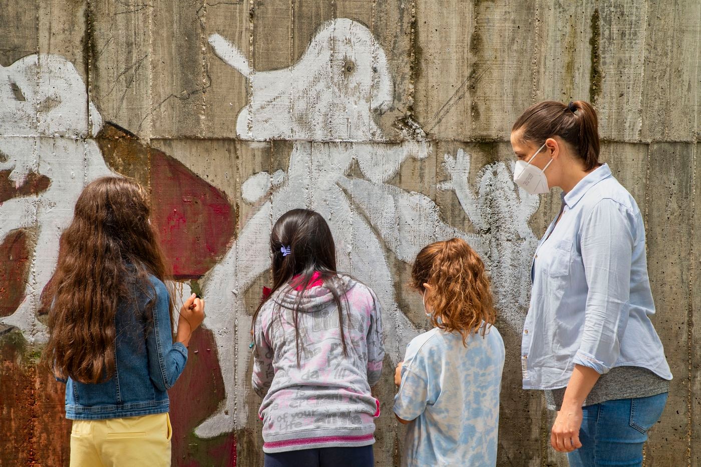 Un mural de superheroínas visibilizará el deporte femenino en el CEIP Margarita Salas de Arroyo (Valladolid), centro vencedor del reto de Afedecyl, impulsado por Iberdrola. En la imagen las niñas que están pintando el mural, junto a los responsables de la iniciativa y profesoras del centro; entre ellos, el dibujante leonés 'lolo'. 