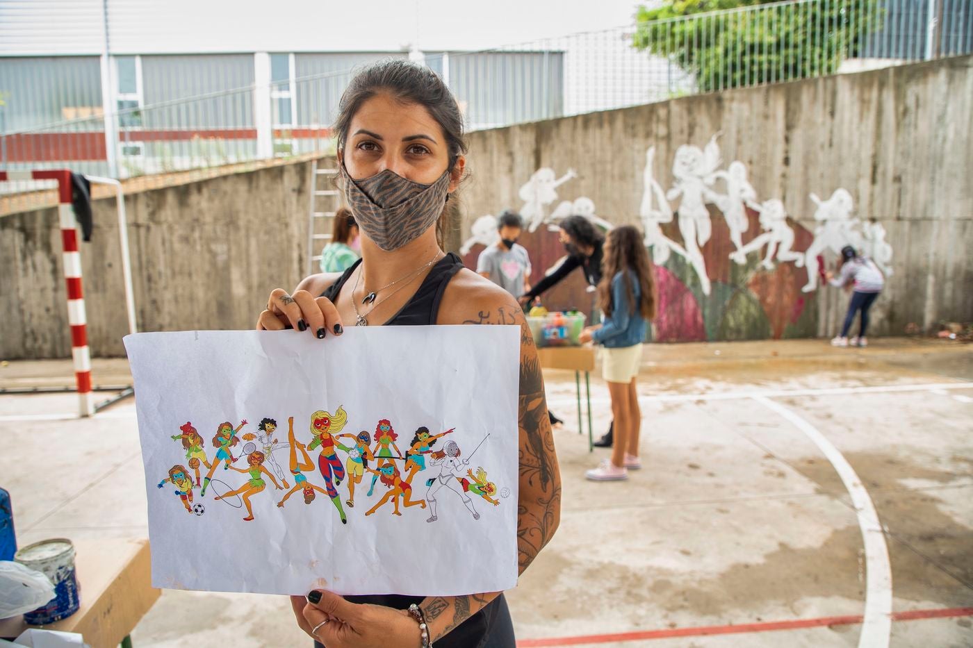 Un mural de superheroínas visibilizará el deporte femenino en el CEIP Margarita Salas de Arroyo (Valladolid), centro vencedor del reto de Afedecyl, impulsado por Iberdrola. En la imagen las niñas que están pintando el mural, junto a los responsables de la iniciativa y profesoras del centro; entre ellos, el dibujante leonés 'lolo'. 