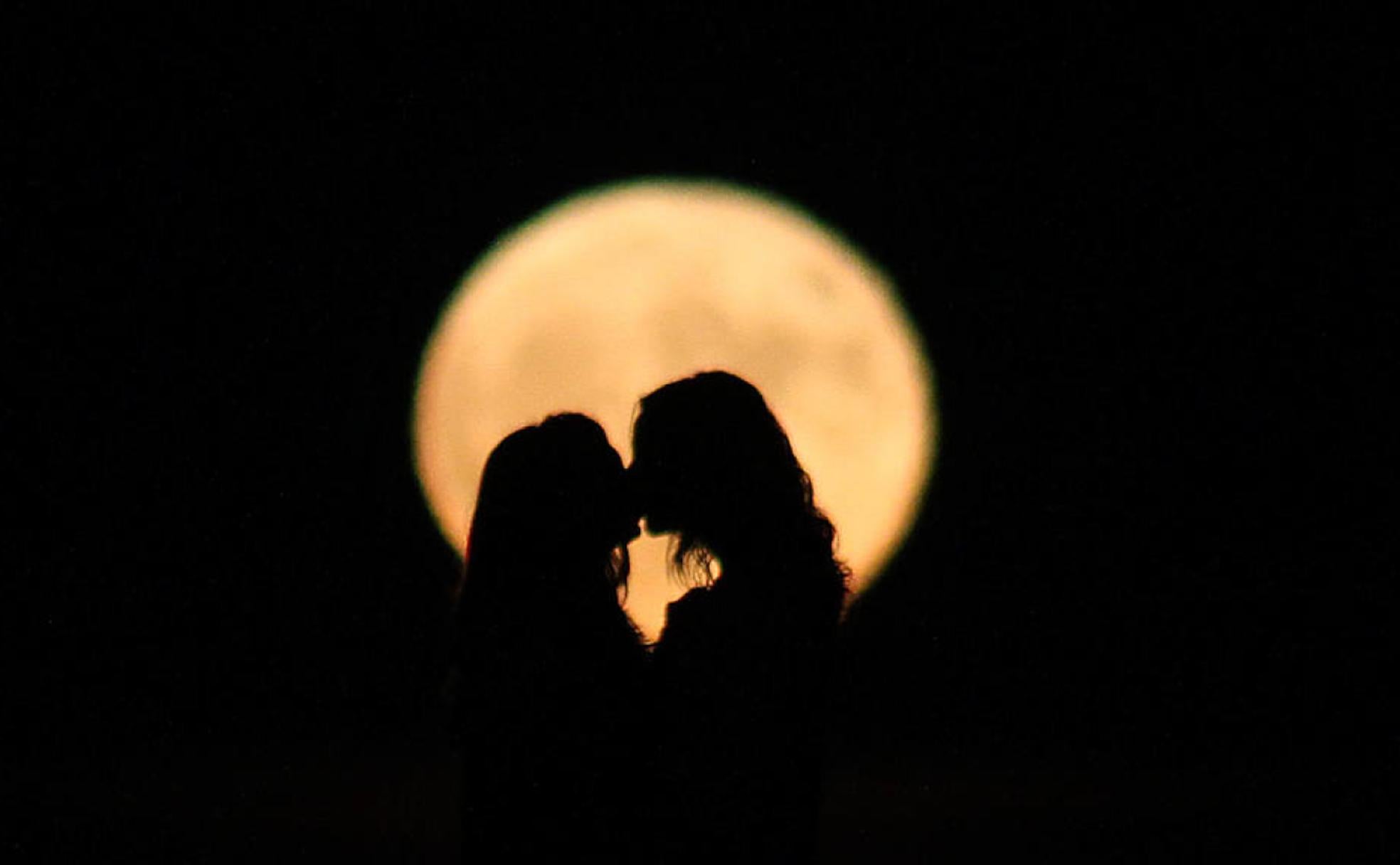 Dos chicas disfrutan de una superluna. 