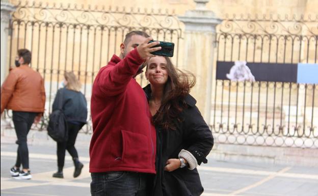 Dos turistas se hacen una fotografía con la catedral de León de fondo. 