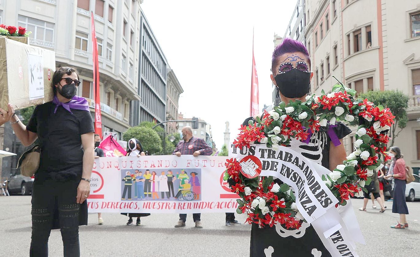 Varios manifestantes desfilan por las calles de León con atuendo de funeral y hasta un ataud.