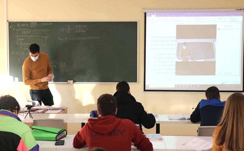 Un docente imparte clase a sus alumnos.