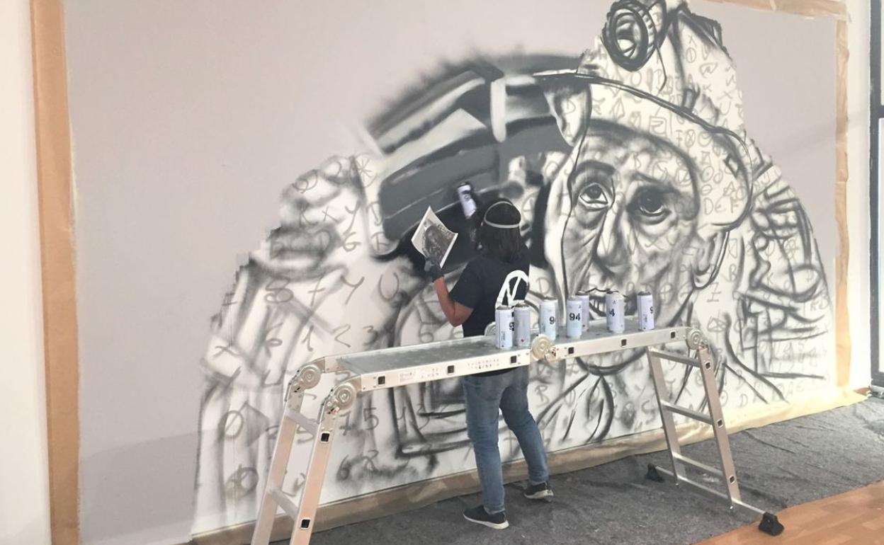 Una de las artistas mientras realiza un grafiti para la exposición.