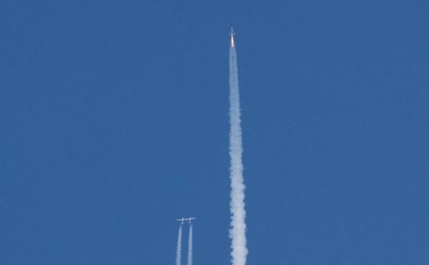 La nave VSS Unity (derecha) en pleno vuelo vertical tras separarse del avión que lo llevó desde su base terrestre.