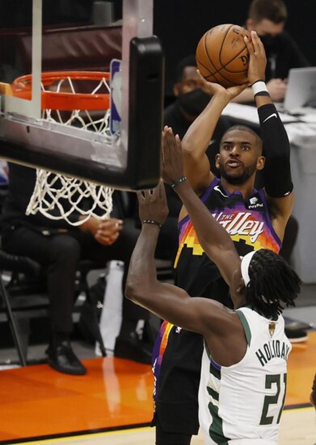 El escolta de los Phoenix Suns, Cris Paul, tirando a canasta mientras Jrue Holiday lo intenta taponar sin éxito. 