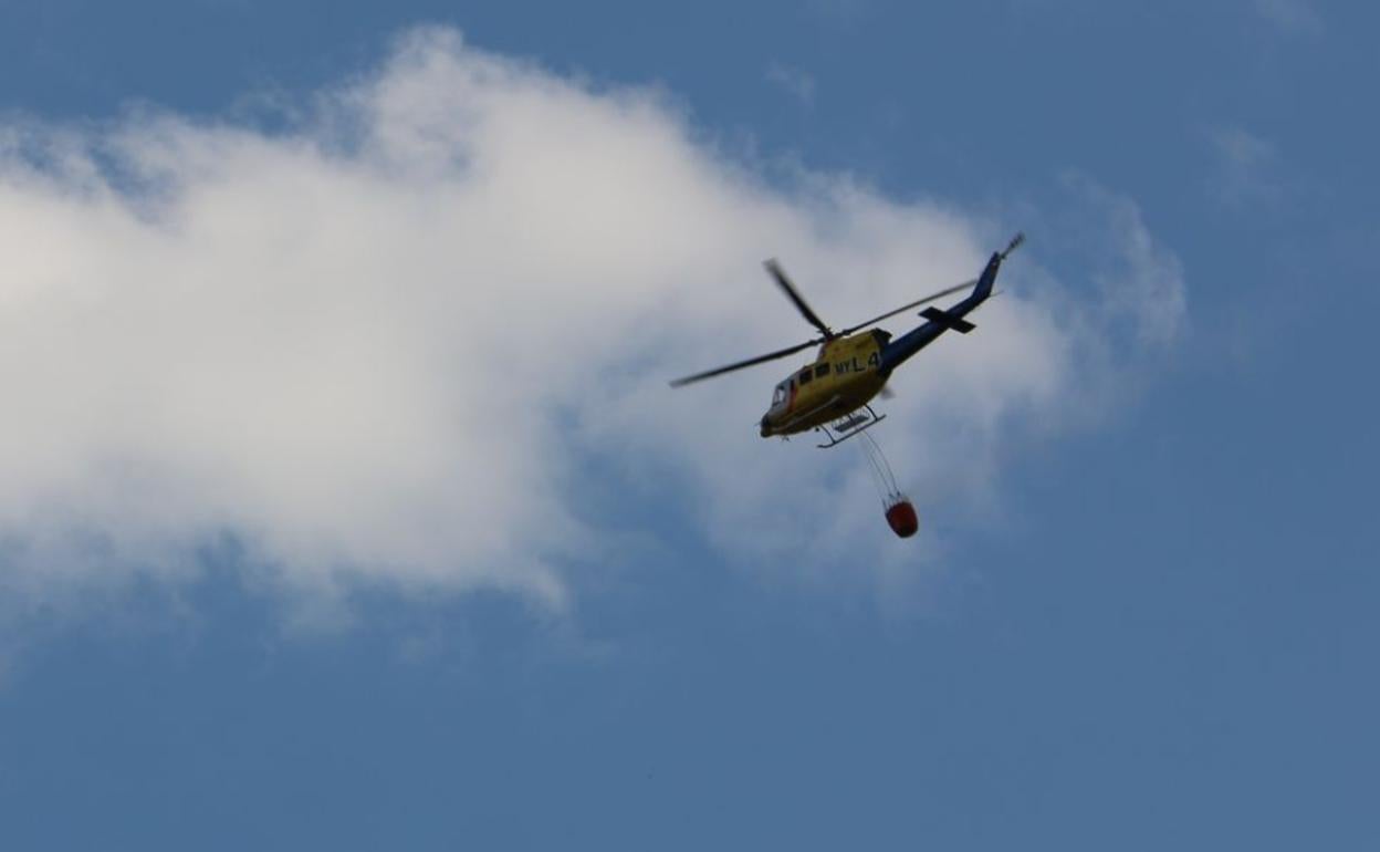 El helicóptero de Sahechores a punto de descargar agua.