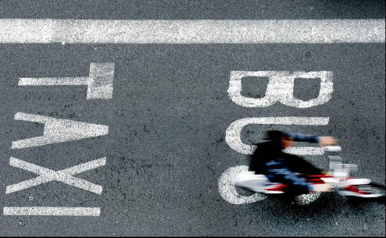 Un usuario del servicio Bicing de Barcelona circula por el carril bus. 