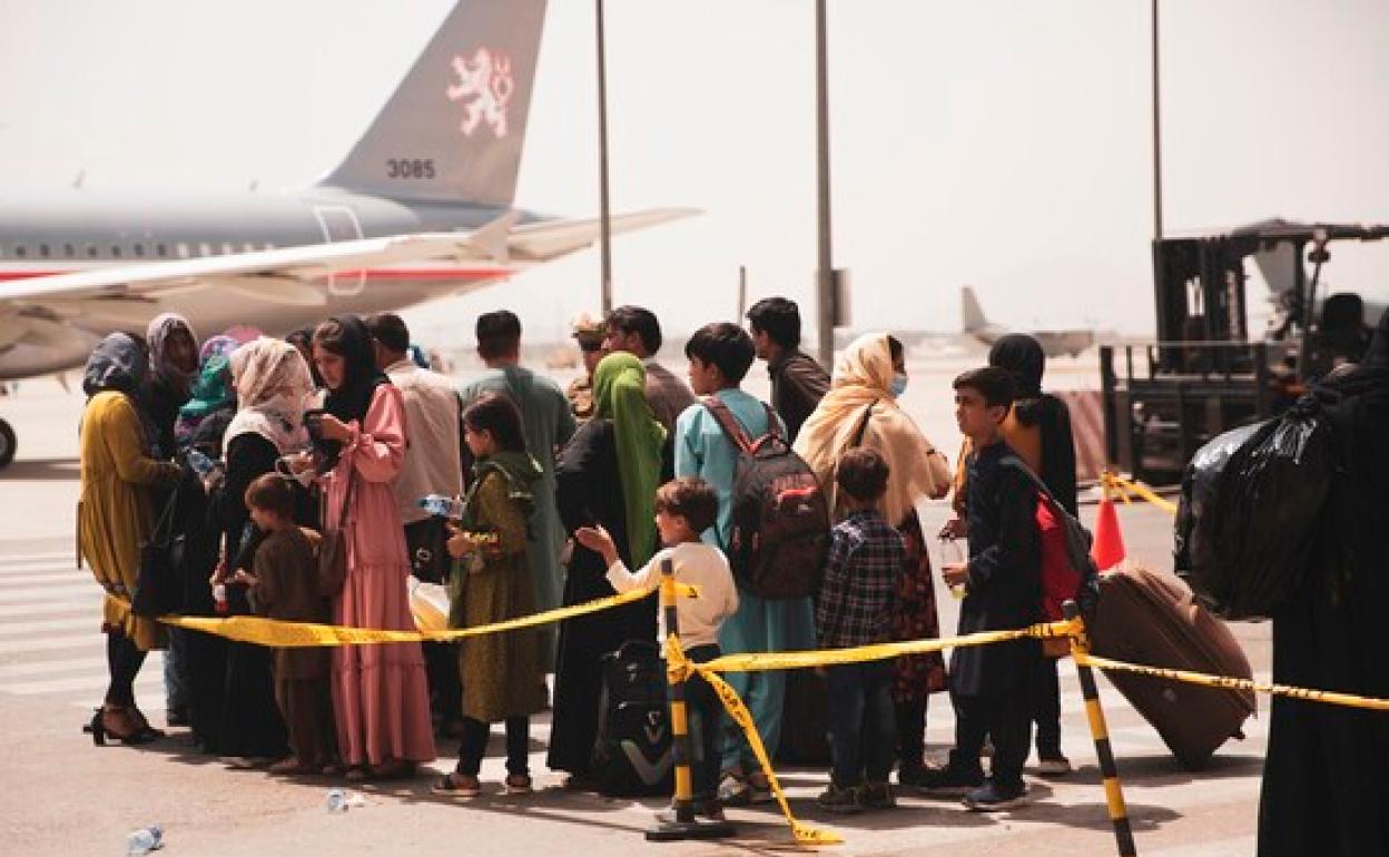 Grupo de afganos esperando en el aeropuerto de Kabul. 