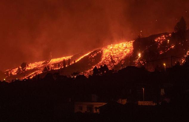 Los flujos de lava se acercan a las casas tras la erupción del volcán.