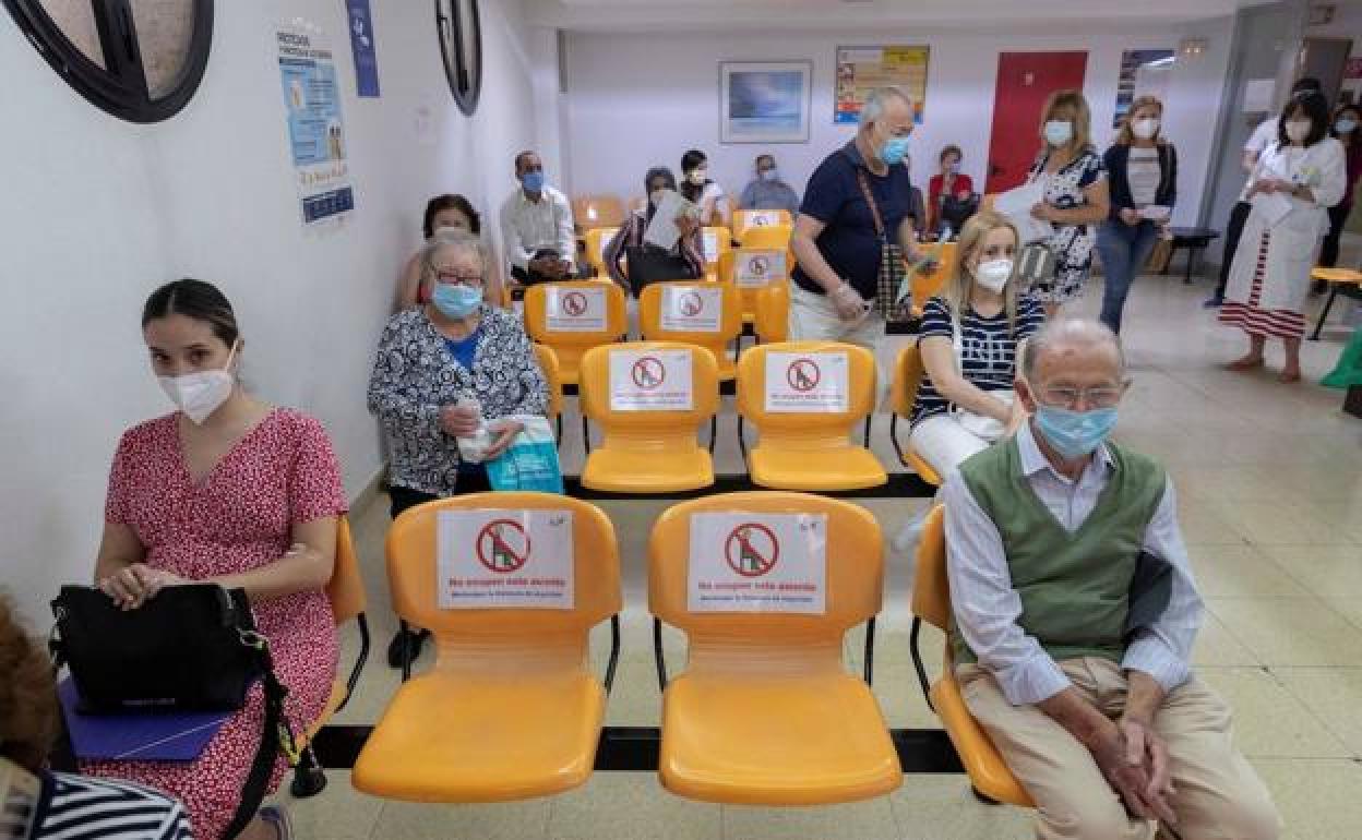 Varias personas esperan su turno en un centro de salud. 