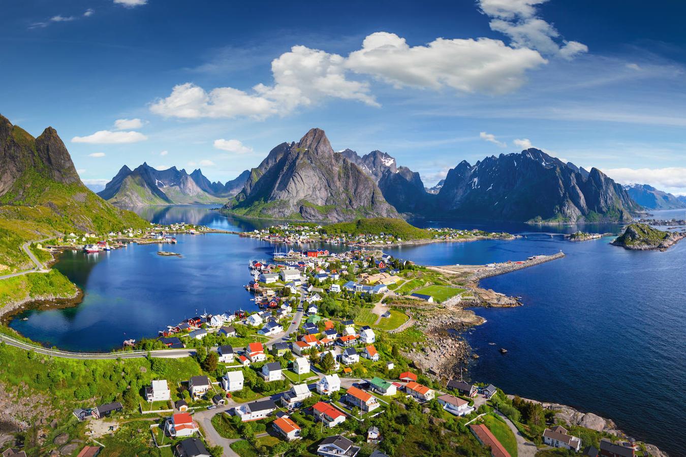 Reine (Noruega): Una perfecta combinación de montañas, acantilados, fiordos, casas típicas de color rojo… Este pueblo de montaña noruego se encuentra en un entorno idílico casi de cuento. Una pintoresca localidad pesquera situada por encima del Círculo Polar Ártico y en el archipiélago de las islas Lofoten protegida por imponentes montañas, las cuales junto con el reflejo del agua se encargan de mostrar una imagen de postal.