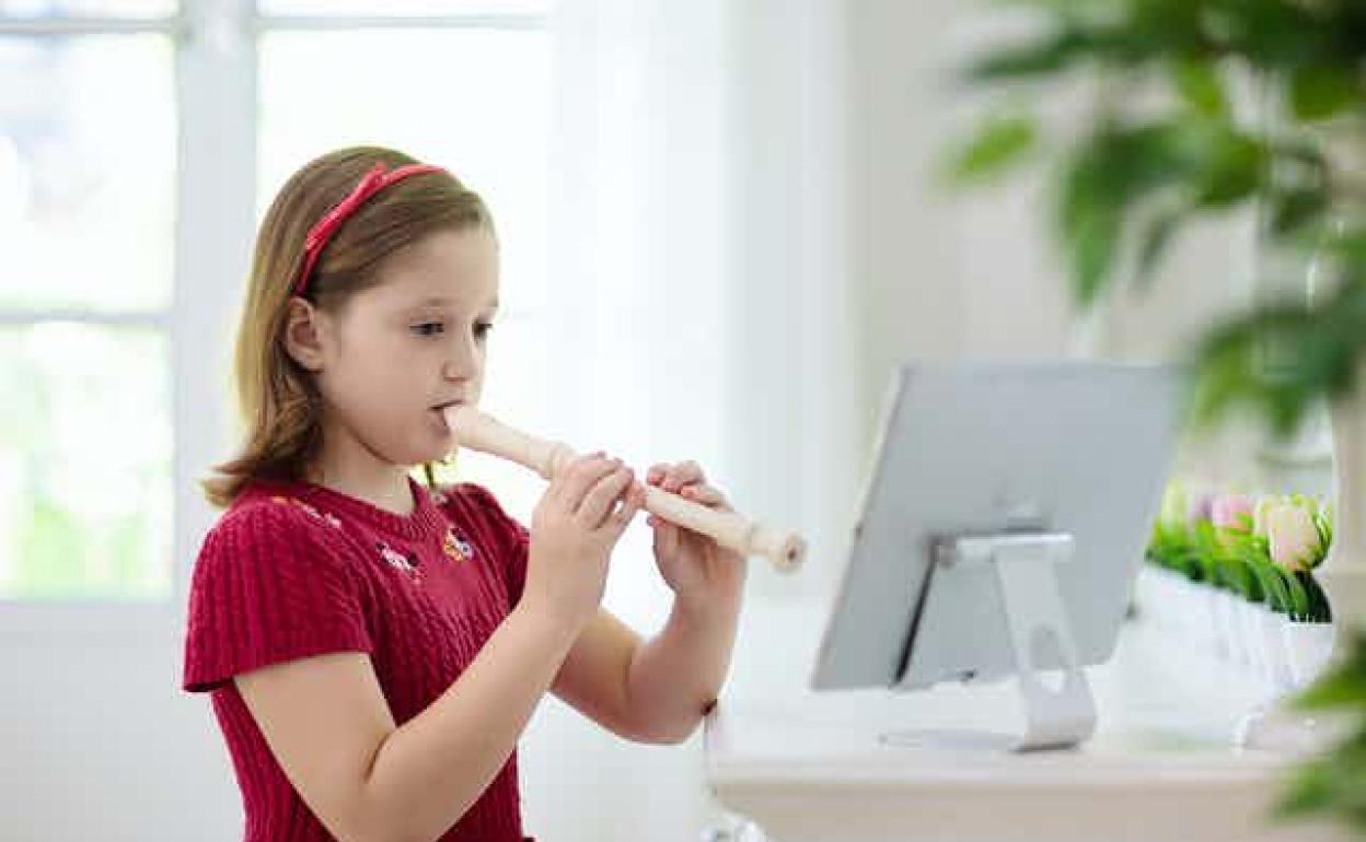 Niña tocando la flauta que se utiliza en los colegios.