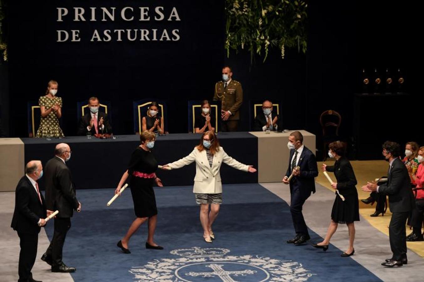 Los científicos premiados por la creación de las vacunas contra la covid se dan la mano tras recibir el galardón.