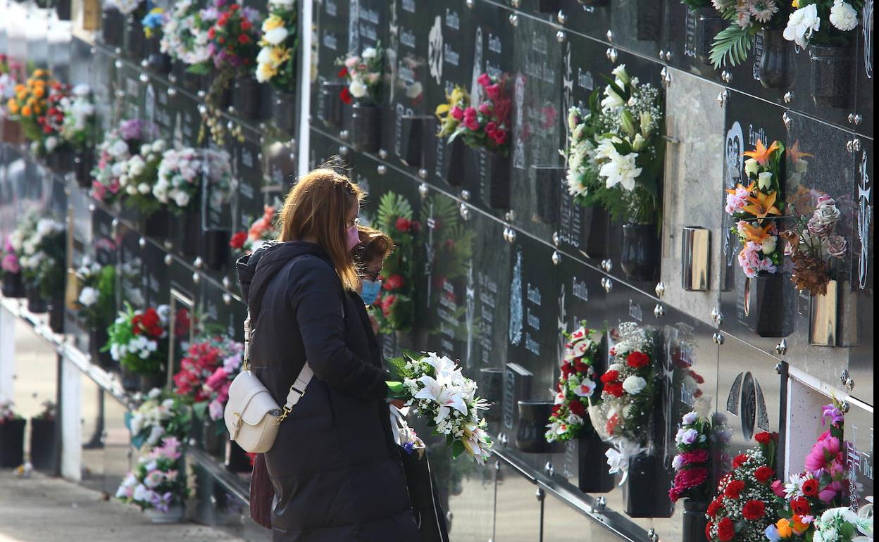 Dos mujeres contemplan un nicho el día de Todos los Santos en el cementerio de Ponferrada