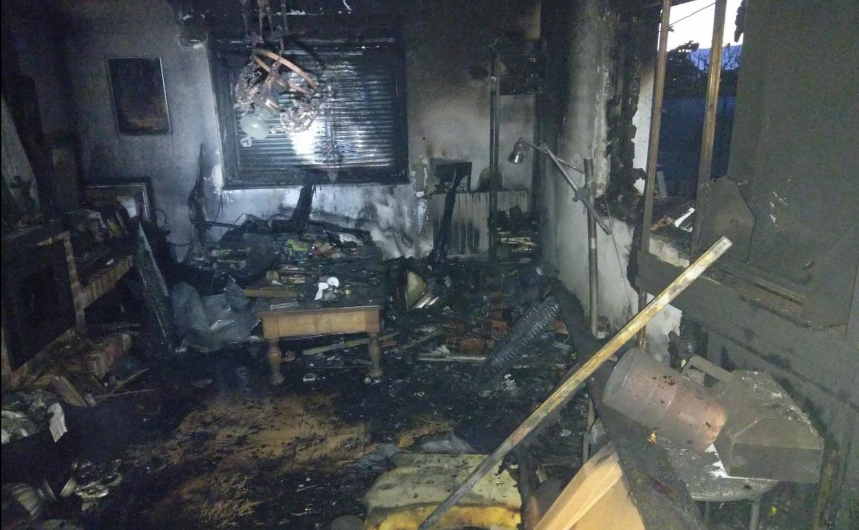 Incendio en una vivienda de Cacabelos en la que resultó muy afectado el salón de la imagen.