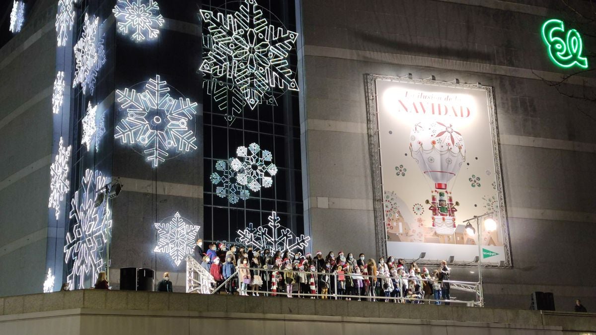 Los niños de las Escuelas Corales han sido los protagonistas del tradicional encendido navideño de la fachada de El Corte Inglés.